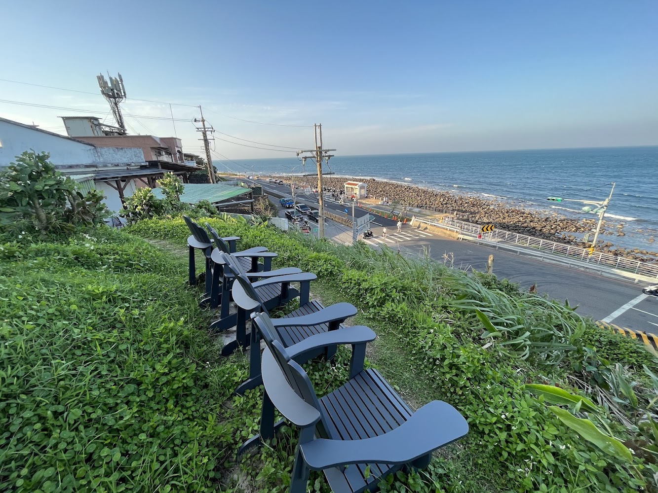 草地上的椅子面向大海與海岸公路