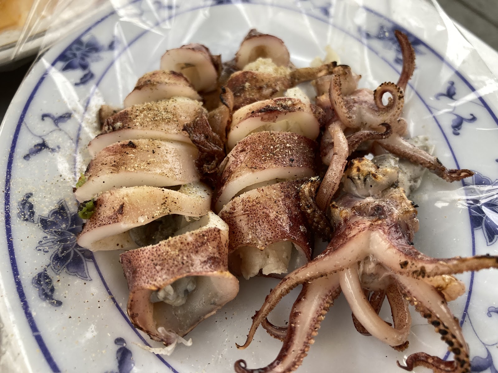 蚵仔寮大酒家青花瓷盤盛裝現烤小卷，色澤金黃