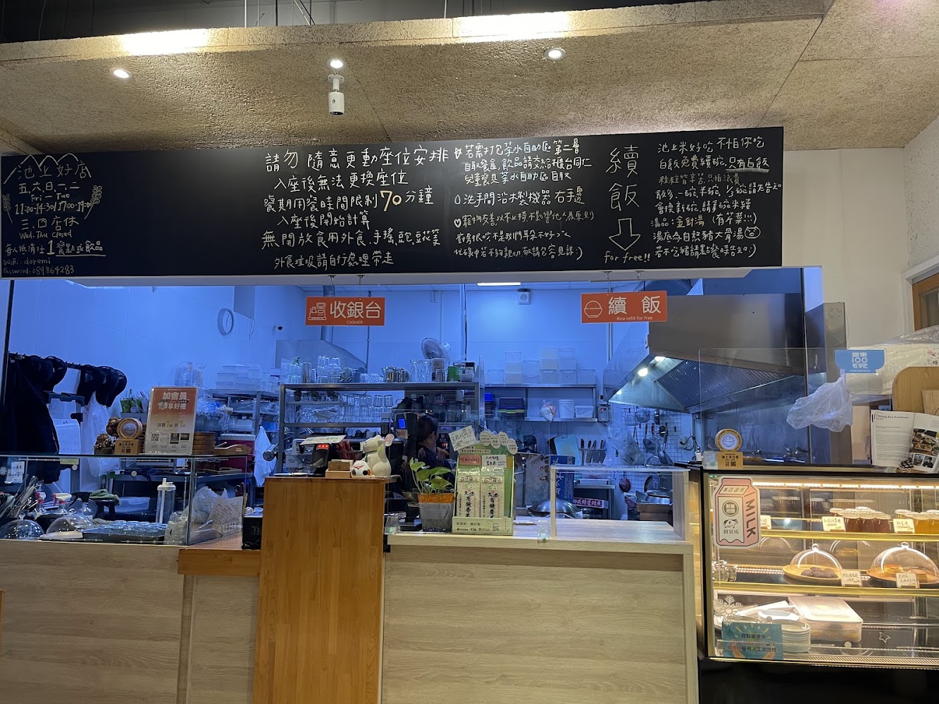 餐廳櫃檯整齊擺放植物與小擺飾，旁邊玻璃櫃展示甜點