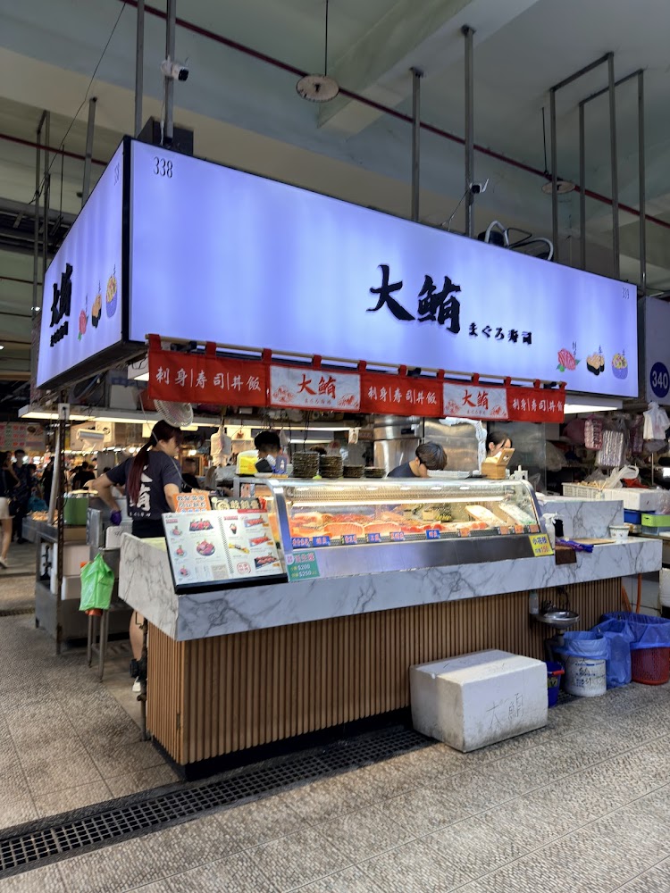 大鮪まぐろ壽司位於市場內，櫃台前可見鮪魚料理與菜單，動線清楚。