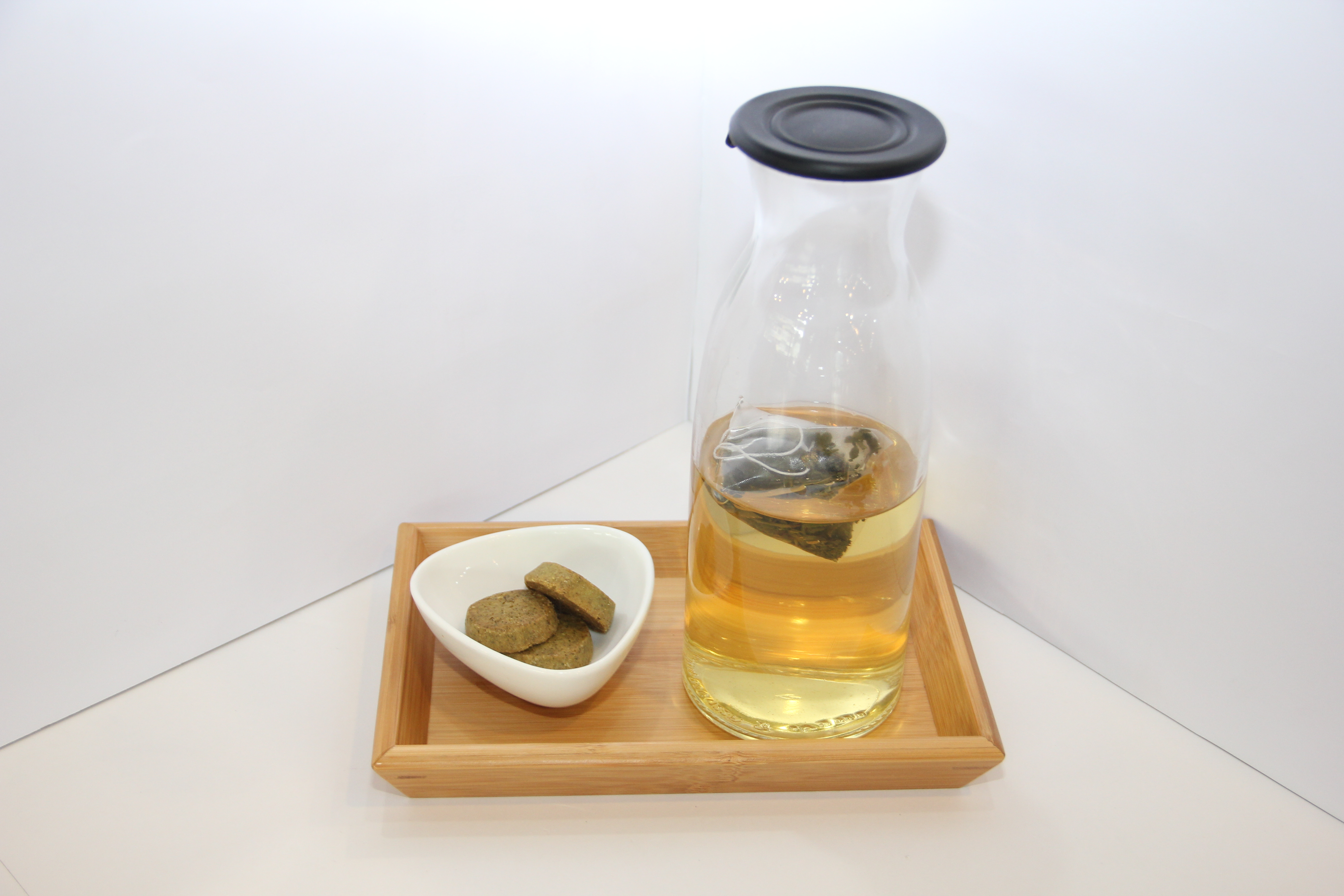 木質托盤上的茶壺與小點心