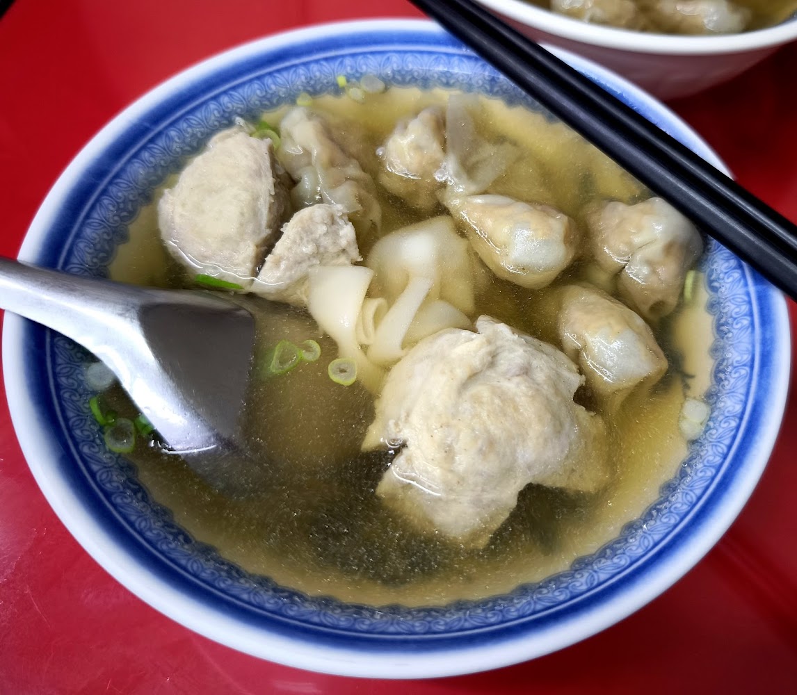 一碗雲吞湯麵，湯裡有雲吞、丸子和寬麵條
