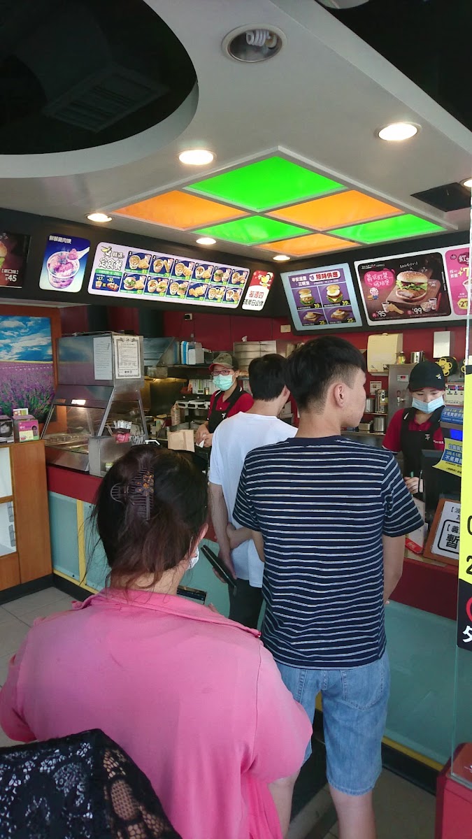 丹丹漢堡店內排隊點餐，彩色天花板燈，熱鬧氣氛