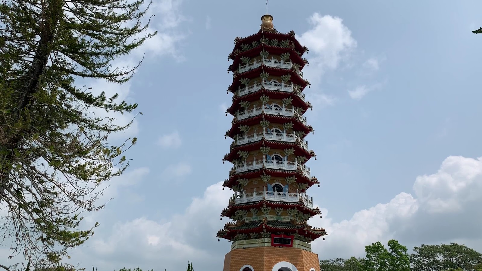 慈恩塔全塔仰拍，紅白飛簷九層寶塔高聳，金頂圓球，左側高大松樹