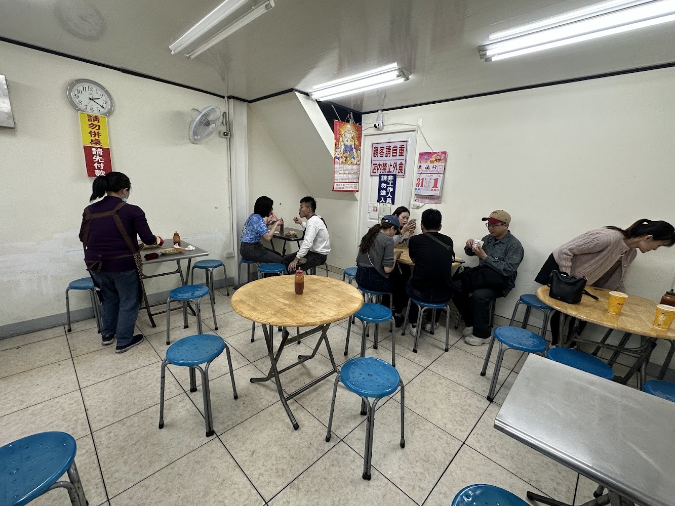 三哥臭豆腐店內用餐空間與圓桌藍椅