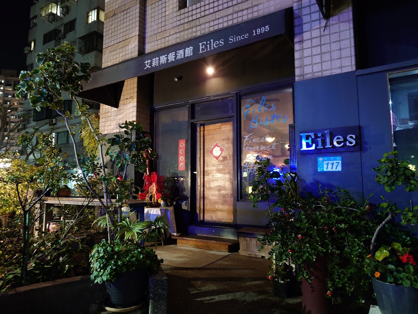 艾莉斯餐酒館夜景店面，有明顯店招、門牌號碼、植物擺設及溫馨門口裝飾