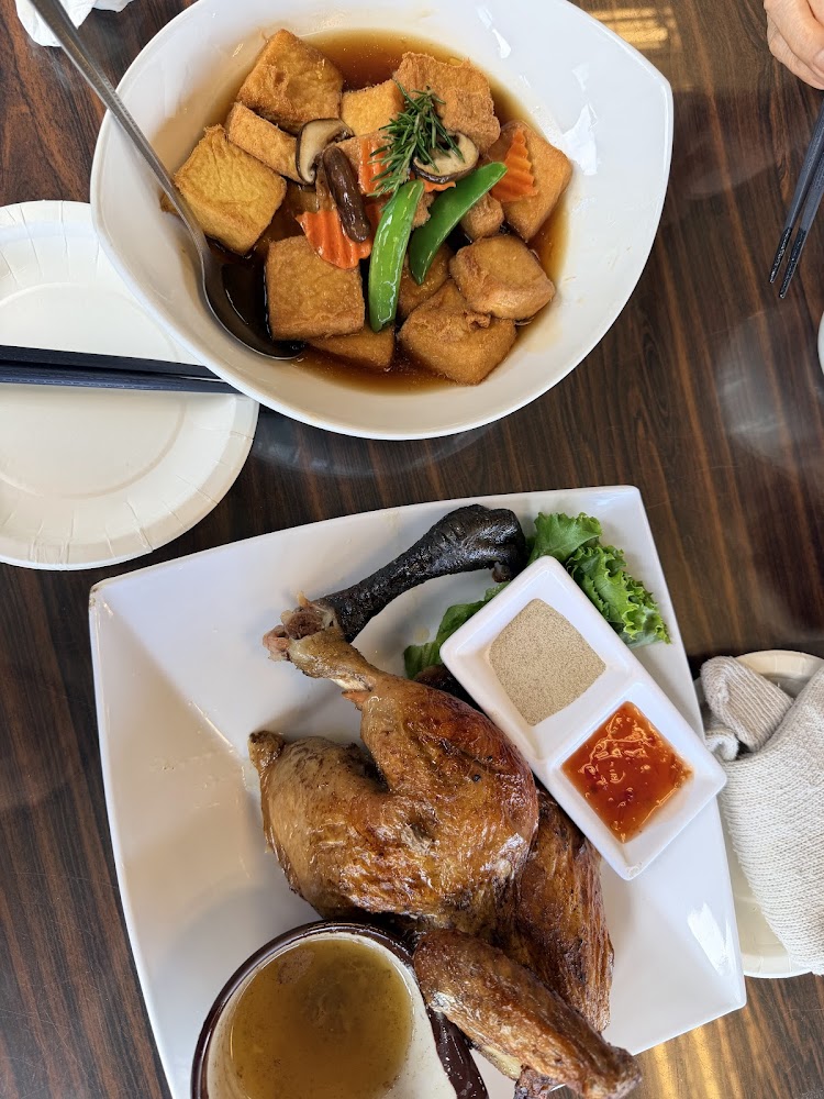 桌上有蔬菜燴豆腐與烤雞兩道料理，旁邊附醬料与調味粉