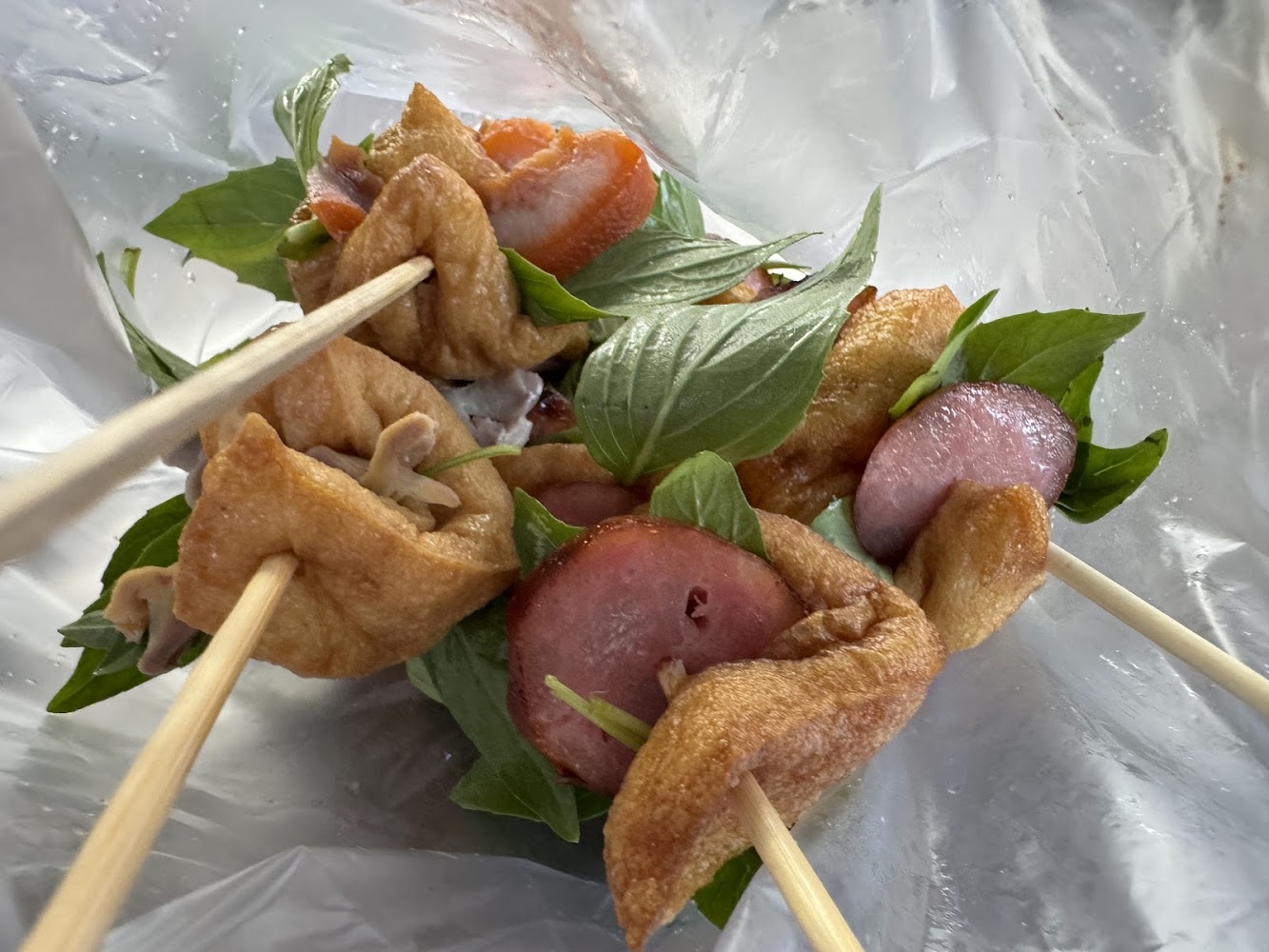 塑膠袋中的香腸甜不辣與九層塔串
