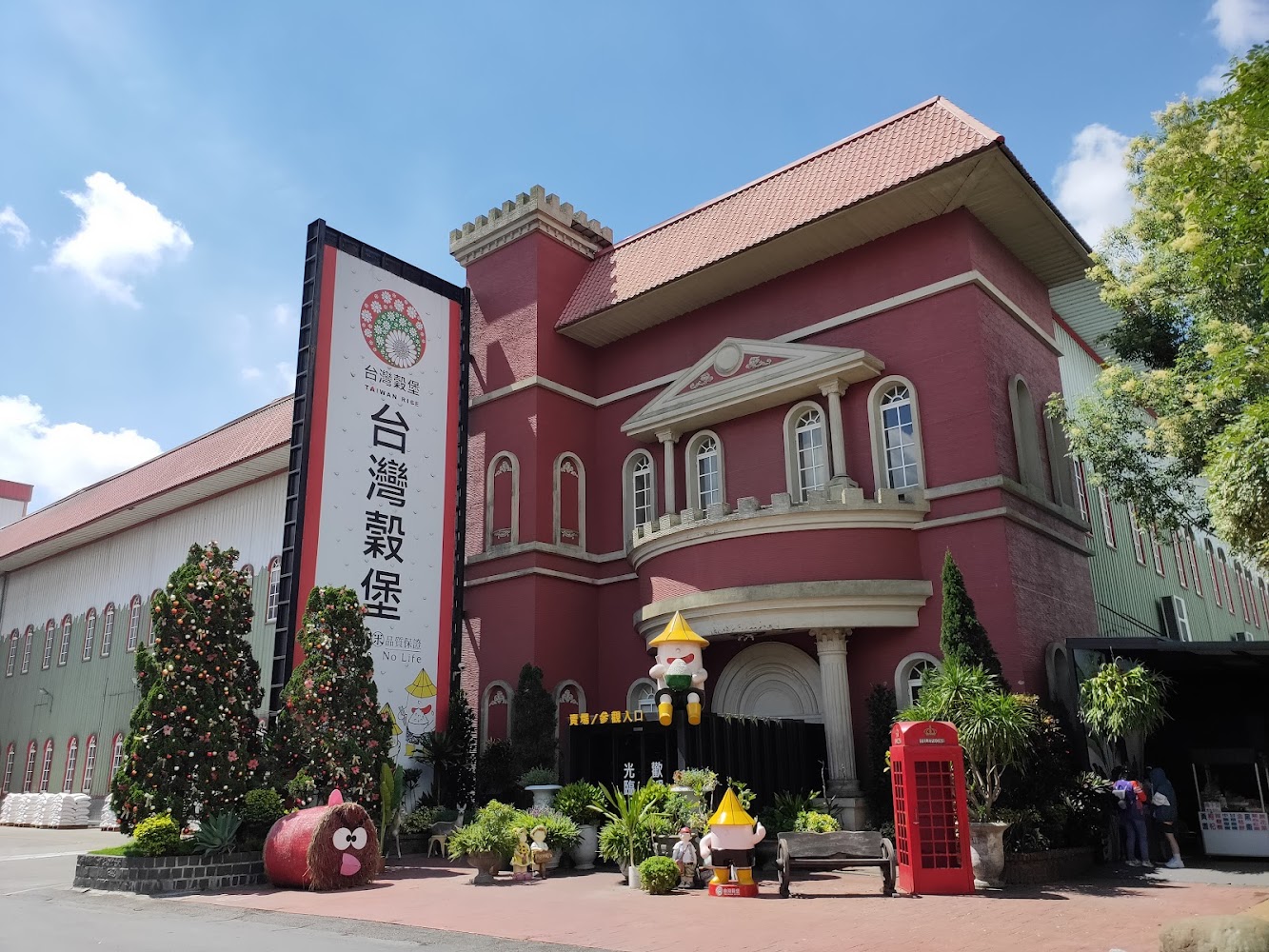 紅色歐式建築前方有台灣穀堡大型直立招牌與可愛裝飾