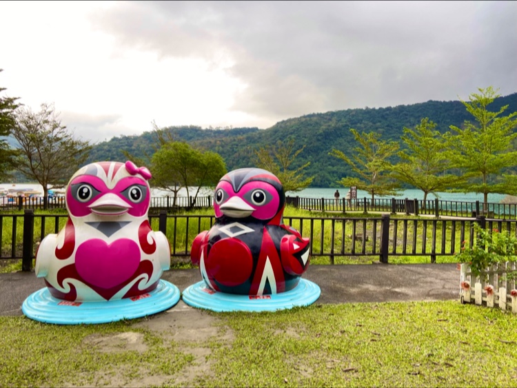 兩個大型鳥形雕塑與湖泊山景