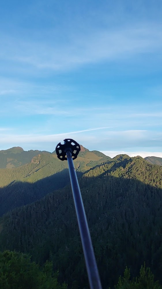 登山杖指向遠方山脈與藍天