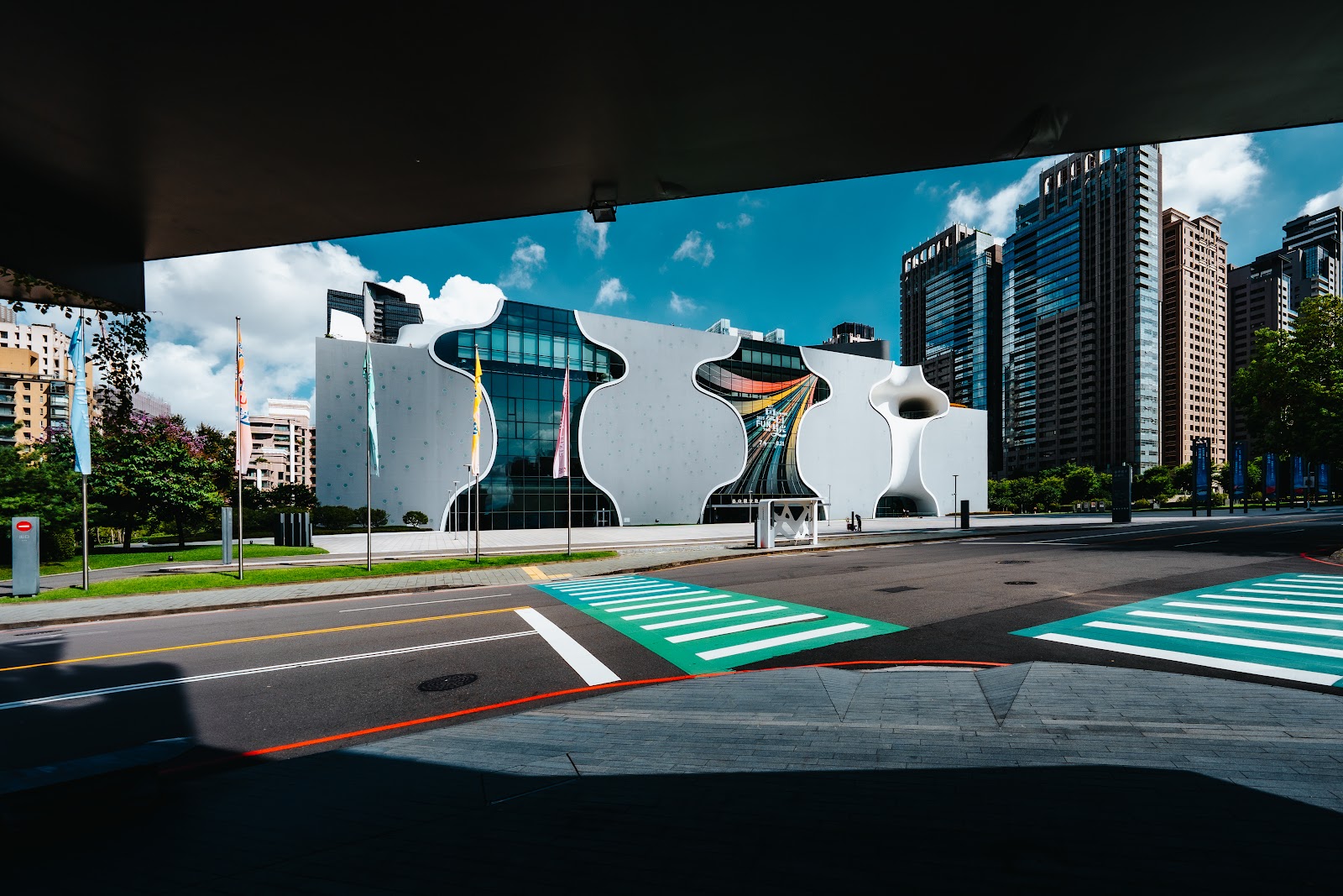 臺中國家歌劇院外觀全景，白色圓弧形建築配上藍天