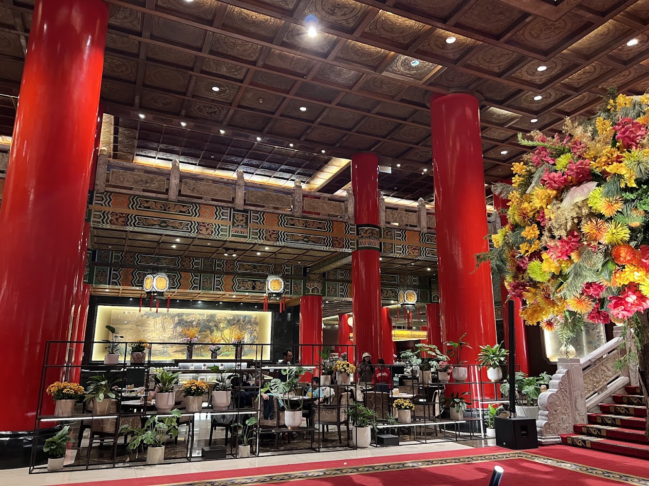 圓山大飯店大廳有紅柱、紅地毯與花卉裝飾