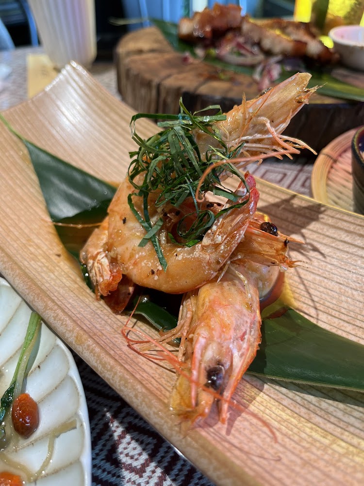 精緻蝦料理放在竹葉上並搭配香草點綴