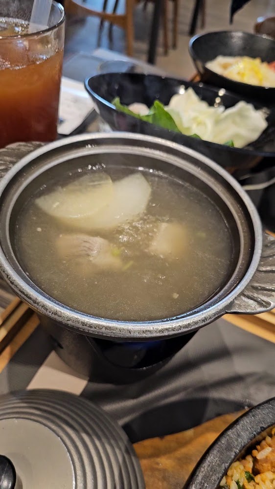 一鍋正在加熱的清湯，湯裡有蘿蔔和肉塊
