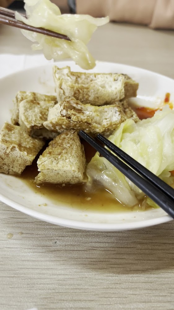 一盤切塊臭豆腐搭配泡菜與醬汁
