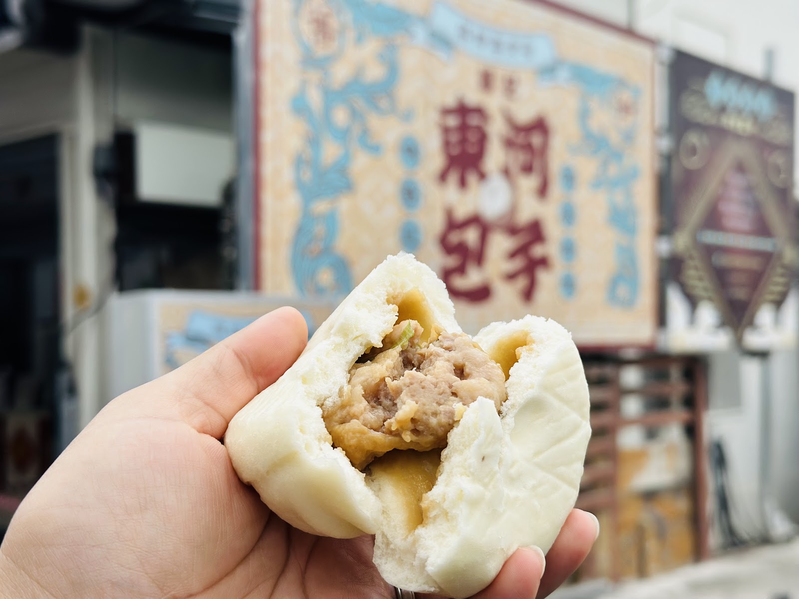 手持纏記東河肉包特寫，肉餡清晰可見