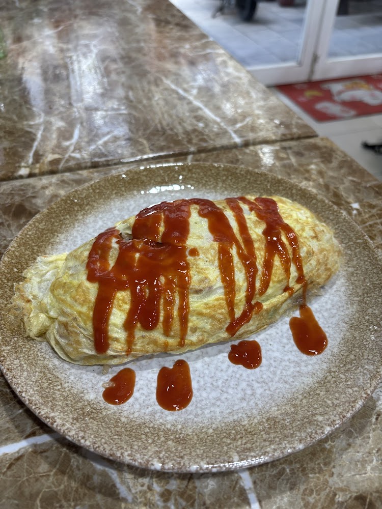 一份日式蛋包飯淋有番茄醬擺在圓盤中