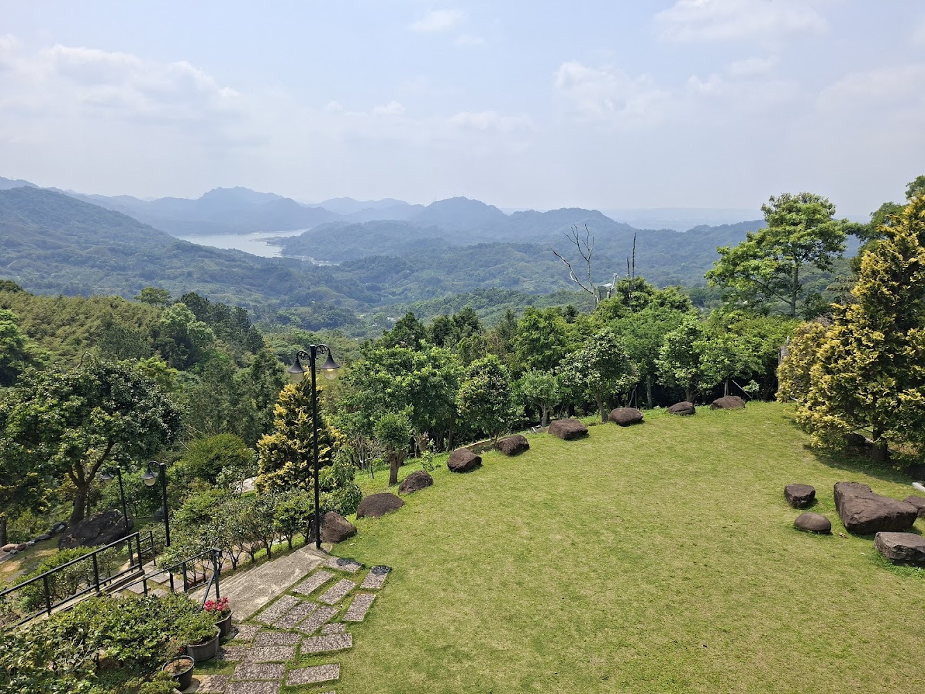 綠意山谷草地大石頭與遠方山巒湖景