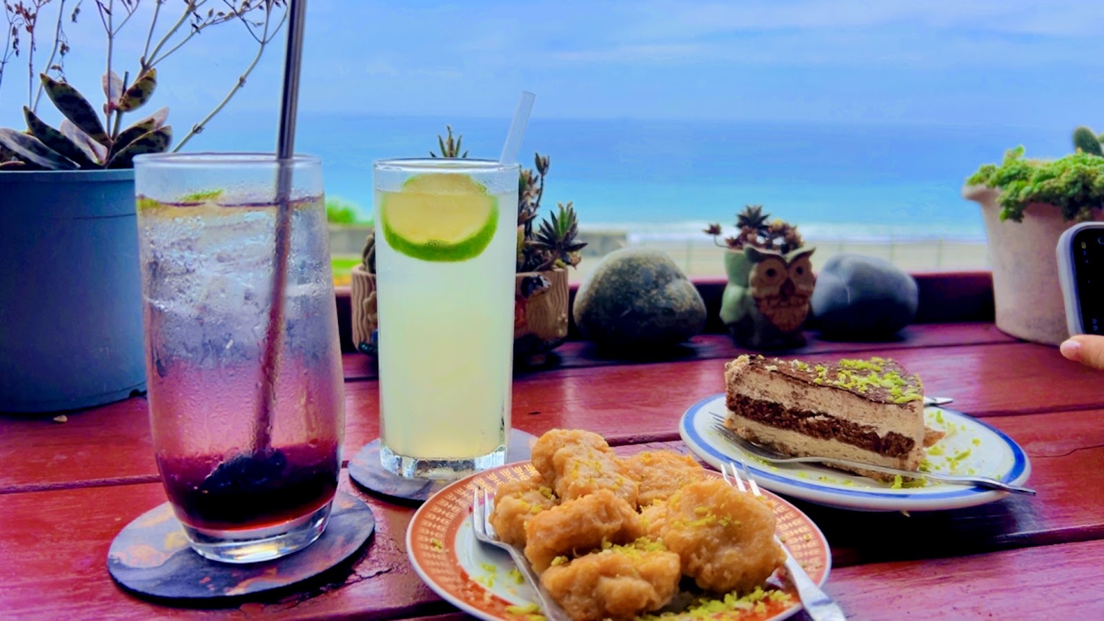 Beach Little 海灘咖啡廳飲品輕食桌景,背景可見台東長濱東海岸碧海藍天