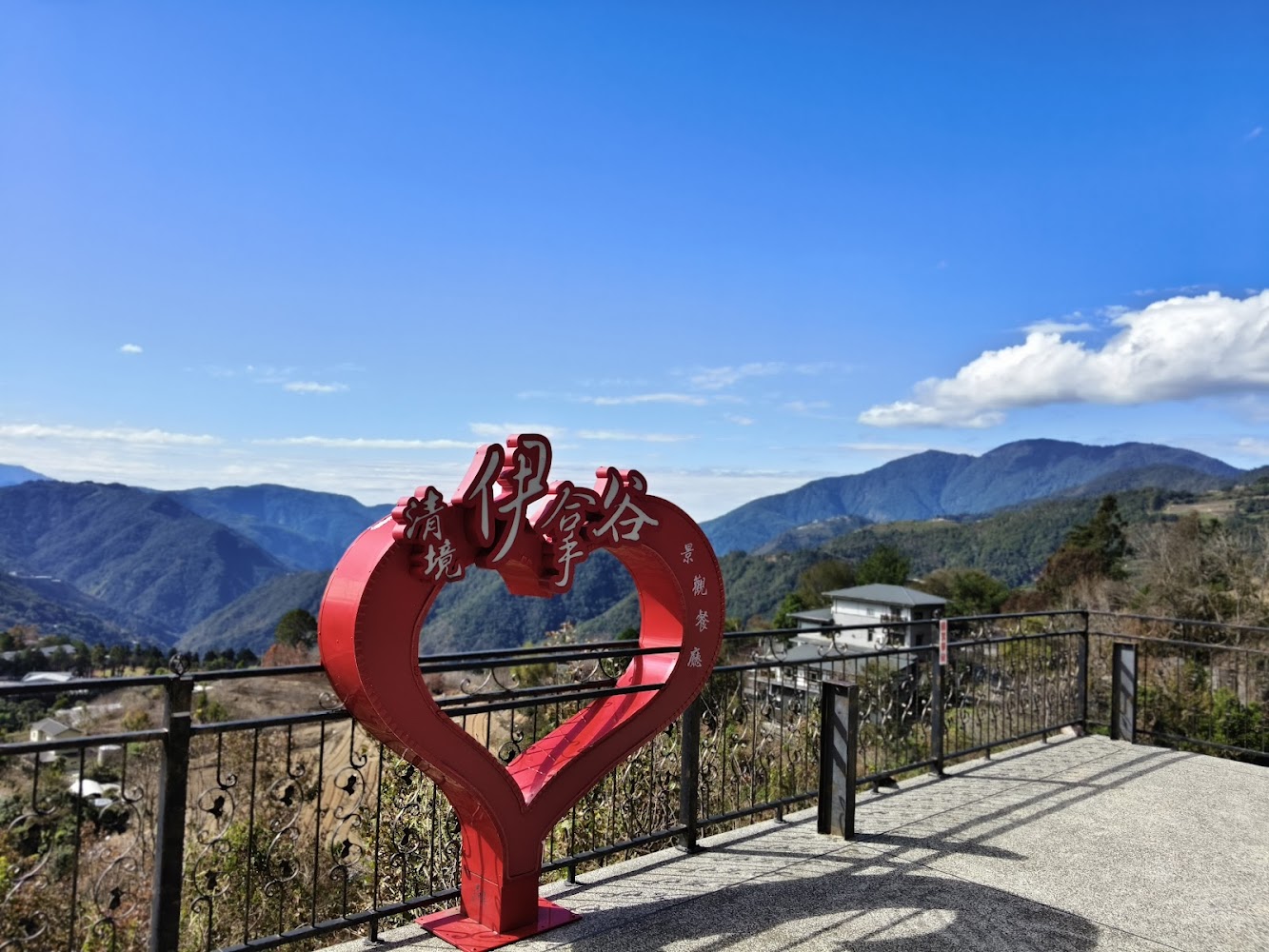 紅色愛心造景上寫著清境伊拿谷景觀餐廳，背景是藍天青山