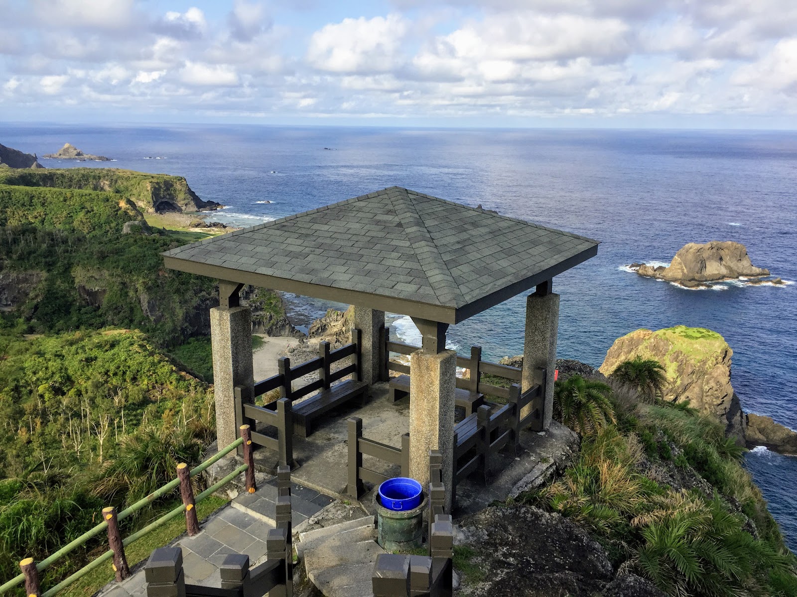 綠島小長城步道山頂觀景亭，藍天白雲與礁岩海景