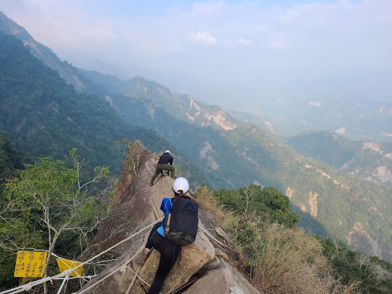 登山者攀爬峭壁並使用繩索輔助