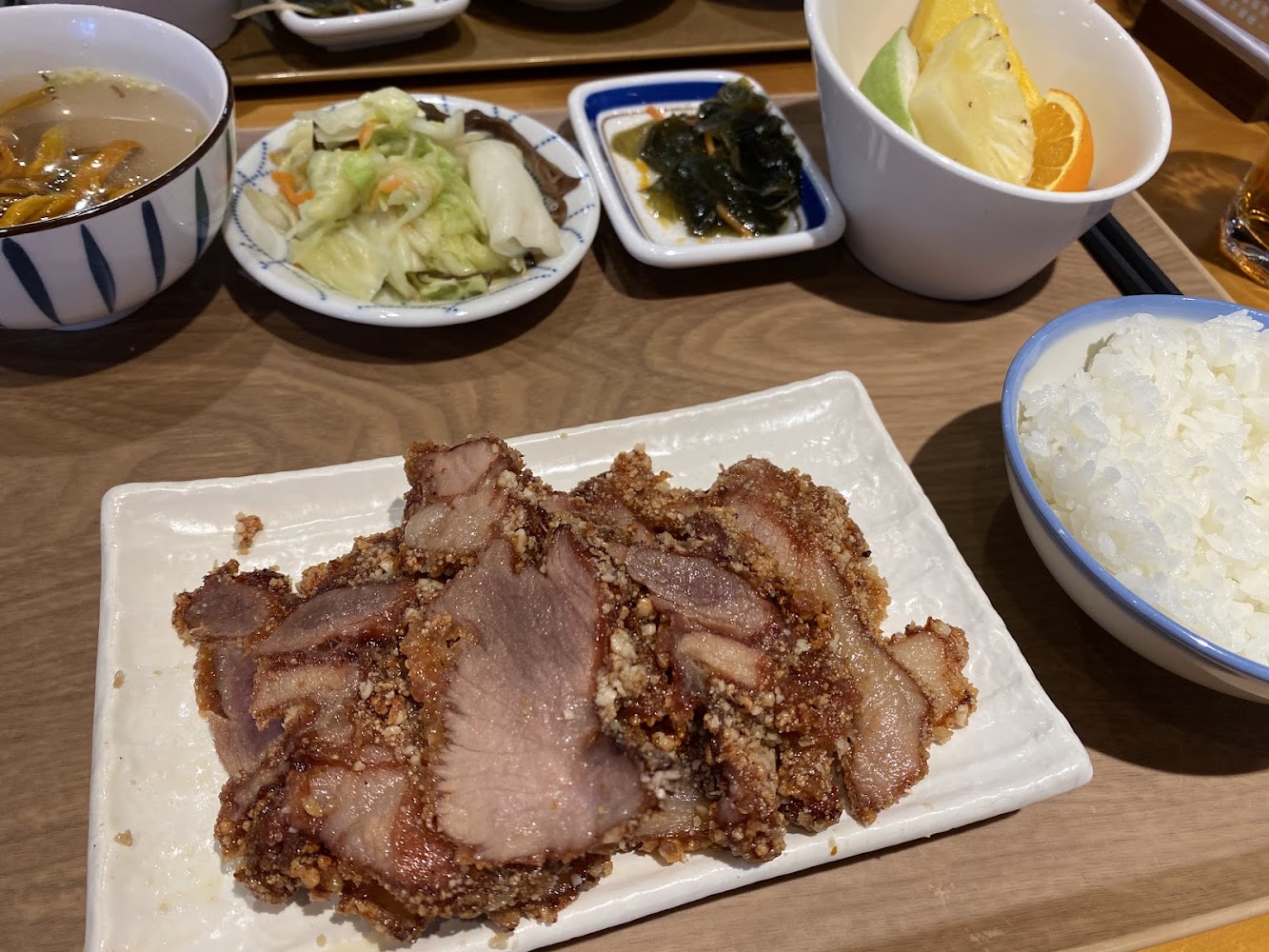 中式套餐有炸豬肉片、白飯、湯、小菜、海帶與水果拼盤