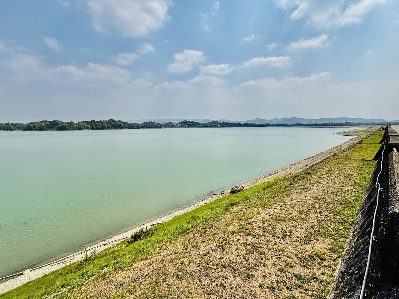 平靜湖面與綠地草坪環繞的阿公店水庫景色