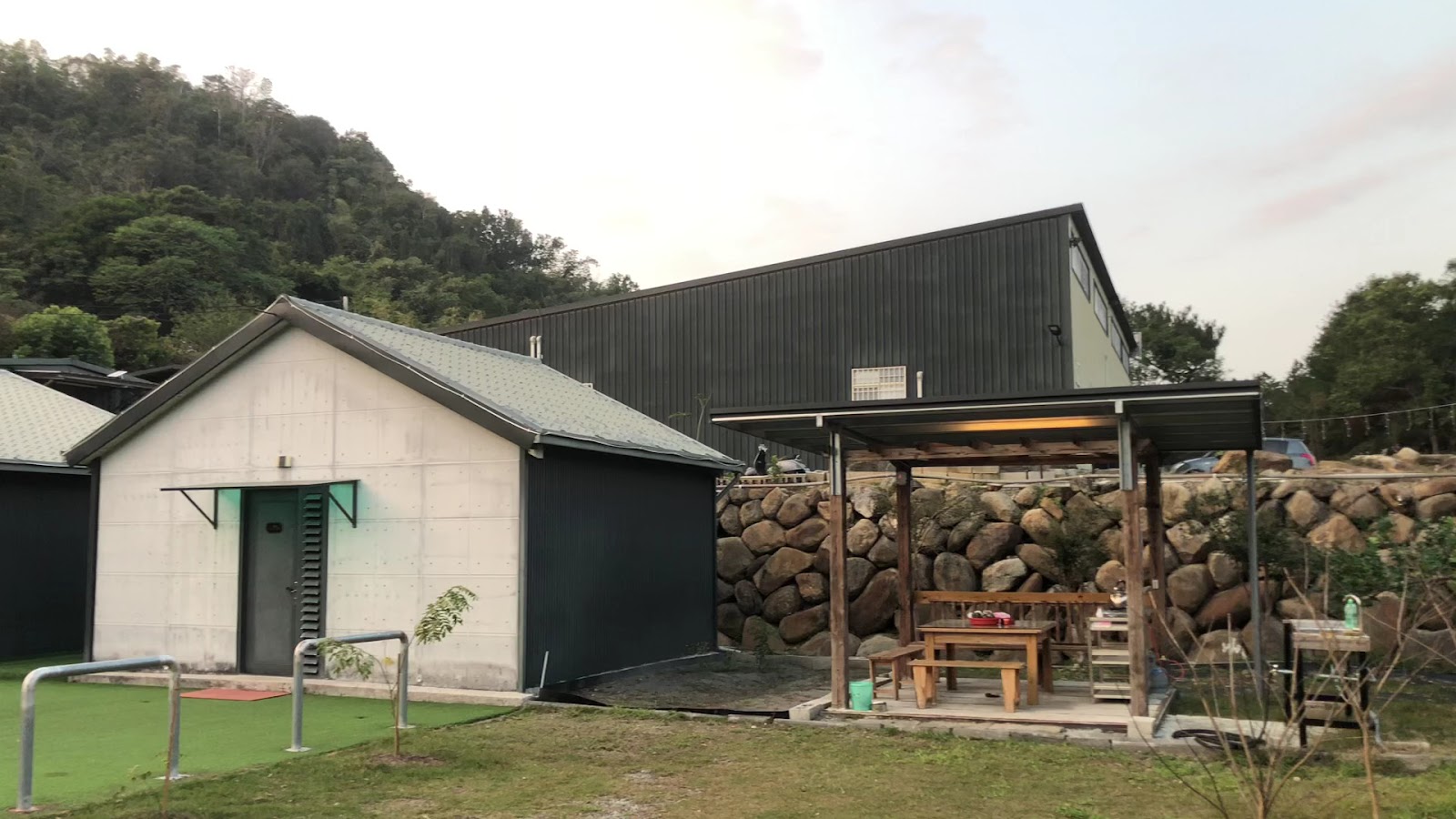 黑爵士民宿工業黑色外觀，戶外木製涼亭與山景