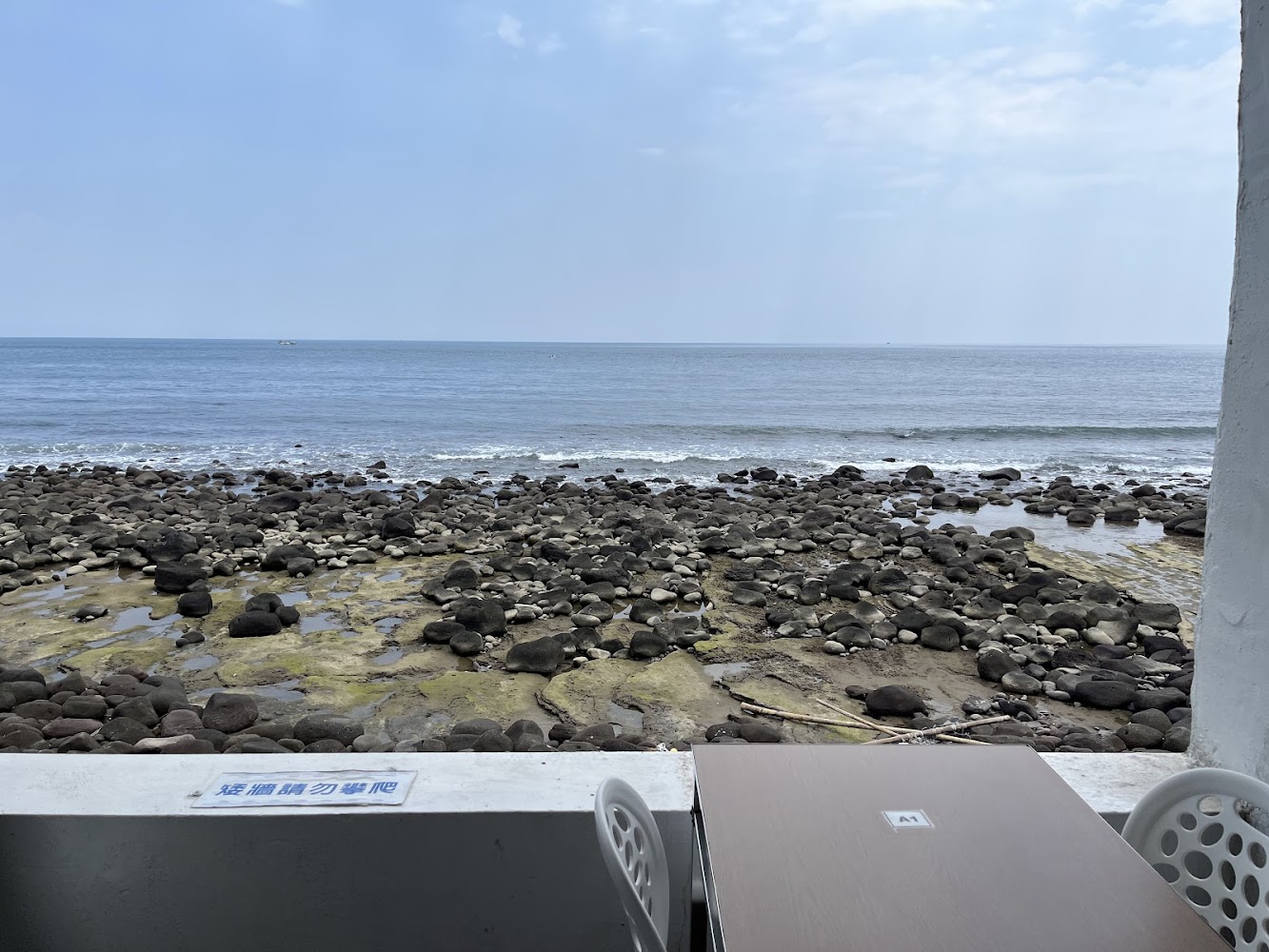戶外海景座位區,前方是岩石海灘與廣闊大海