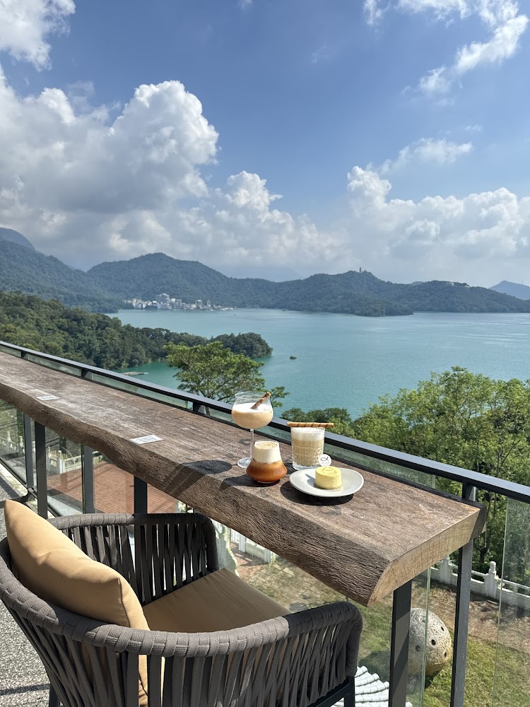 湖景露台上擺著三杯飲品和甜點的愜意畫面