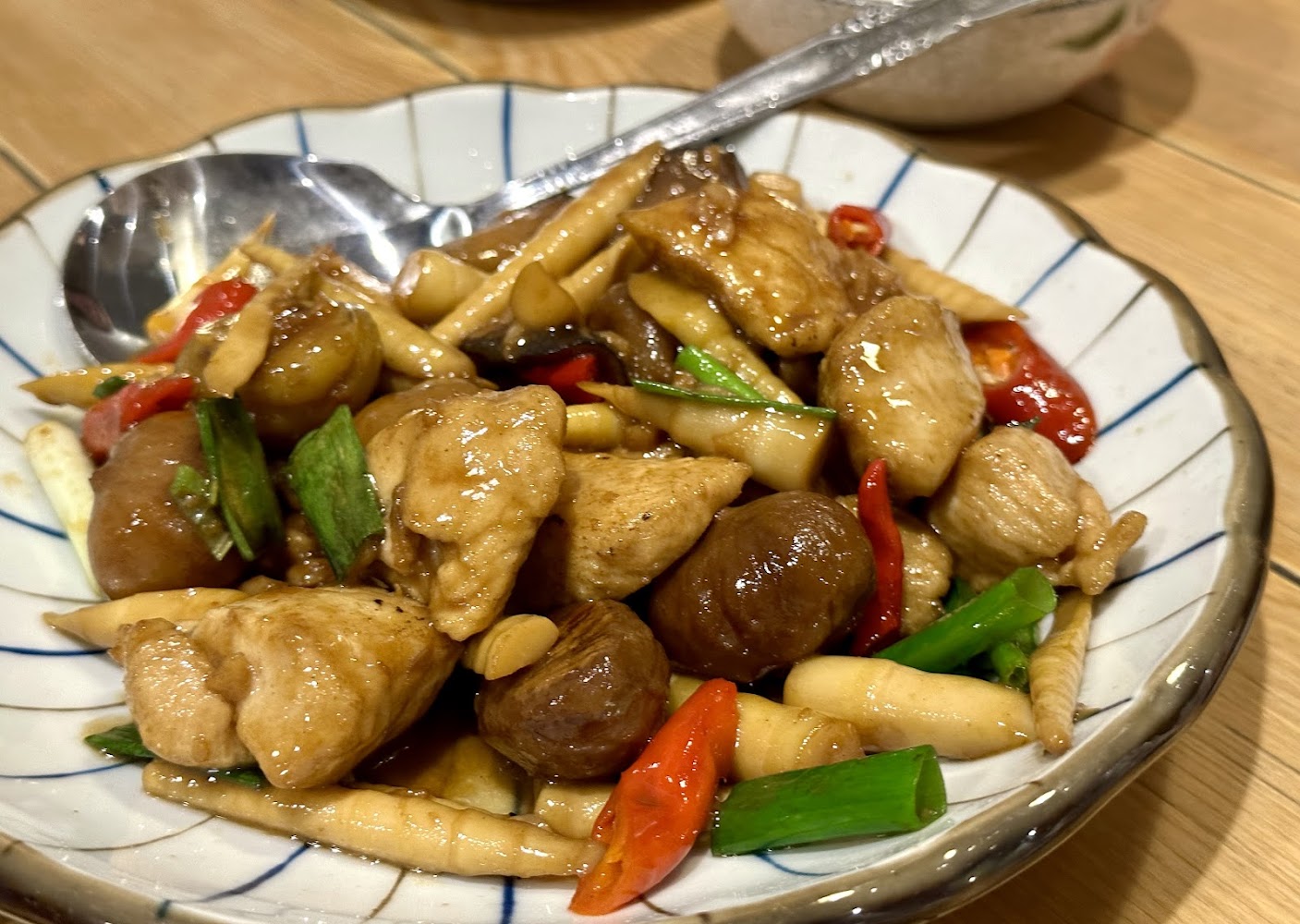 中式炒菜，有雞肉、香菇、筍子、紅辣椒與蔥段。