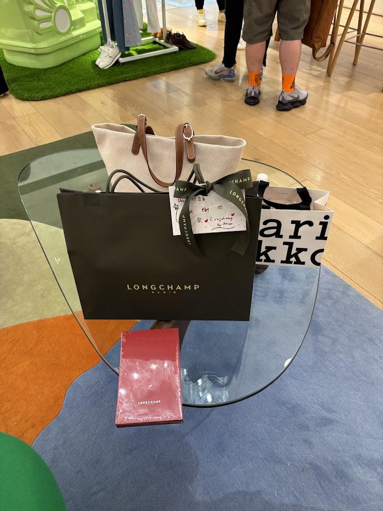 Longchamp 台中新光三越中港店桌上擺放購物袋、托特包與品牌包裝