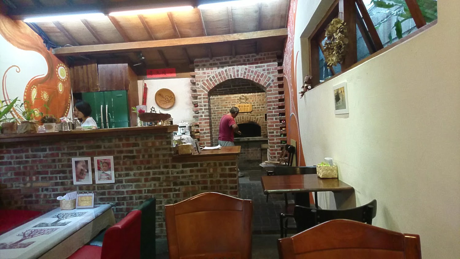 餐廳內部有磚造壁爐與廚師工作畫面，氛圍溫馨