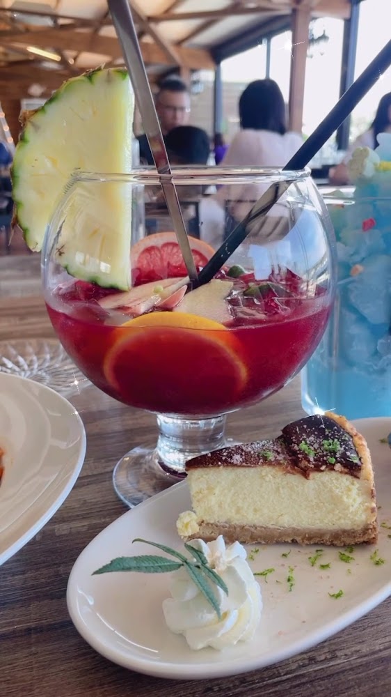 水果紅飲與起司蛋糕及鮮奶油擺在桌上