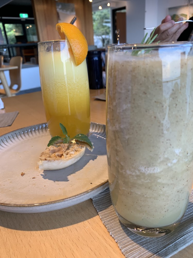 兩杯飲料分別是橙汁和奶昔，旁邊有一塊小麵包