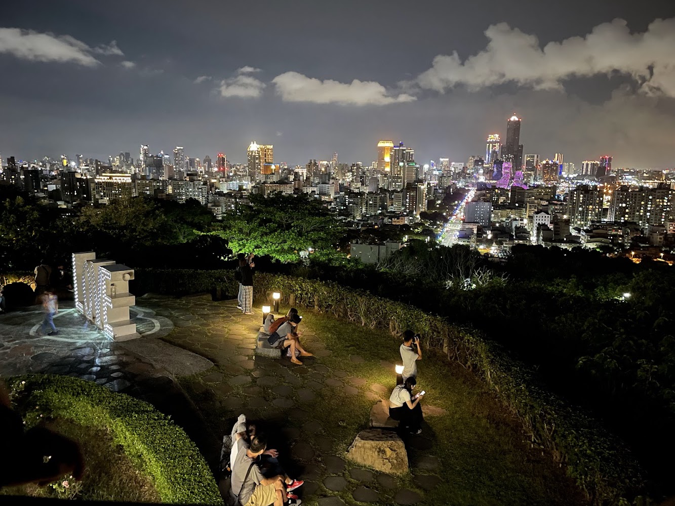 夜晚展望台有遊客欣賞城市燈火，氛圍悠閒寧靜。