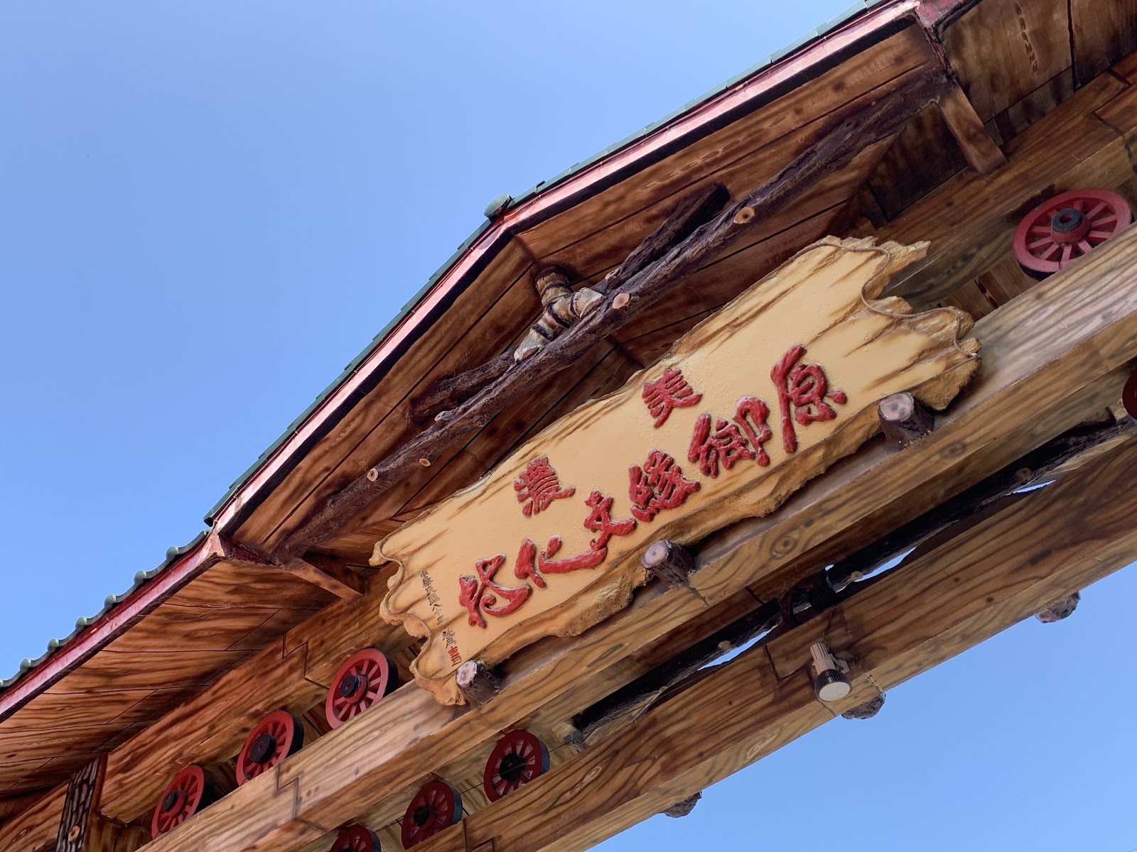 美濃原鄉緣紙傘文化村木製招牌仰拍，藍天背景
