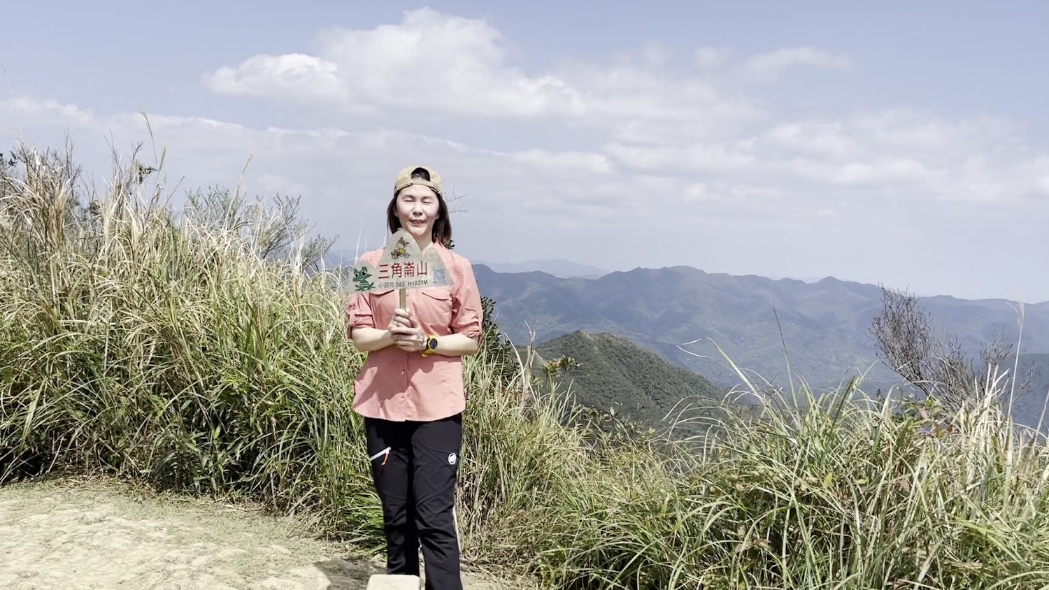 登山者在三角崙山山頂與標示牌合影