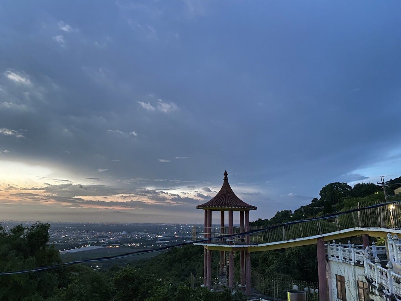山上的中式涼亭、步道與夕陽下的城市景觀