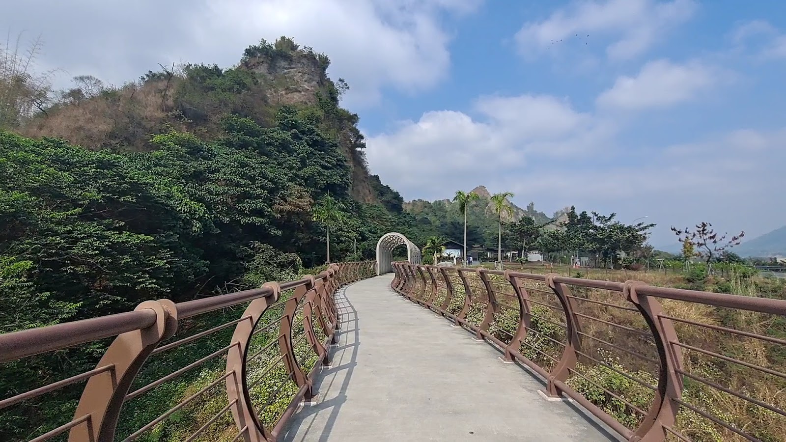 十八羅漢山觀景步道橋，棕色欄杆延伸通往拱門入口