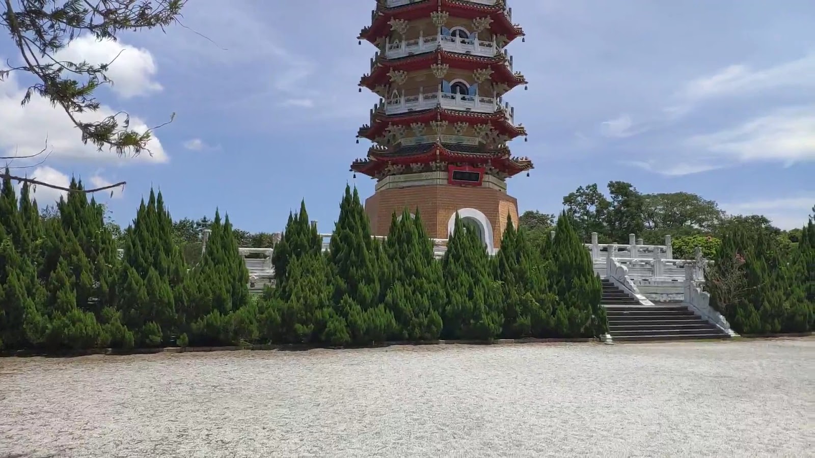慈恩塔近景仰拍，紅白多層飛簷寶塔，前有翠綠柏樹，石階石欄
