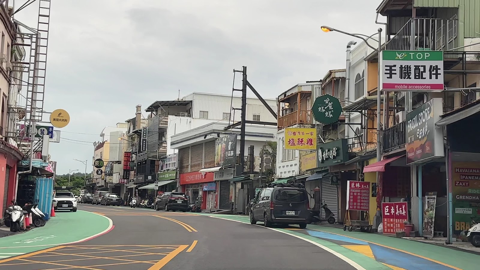 白天墾丁大街商店街景，彩色招牌商店林立