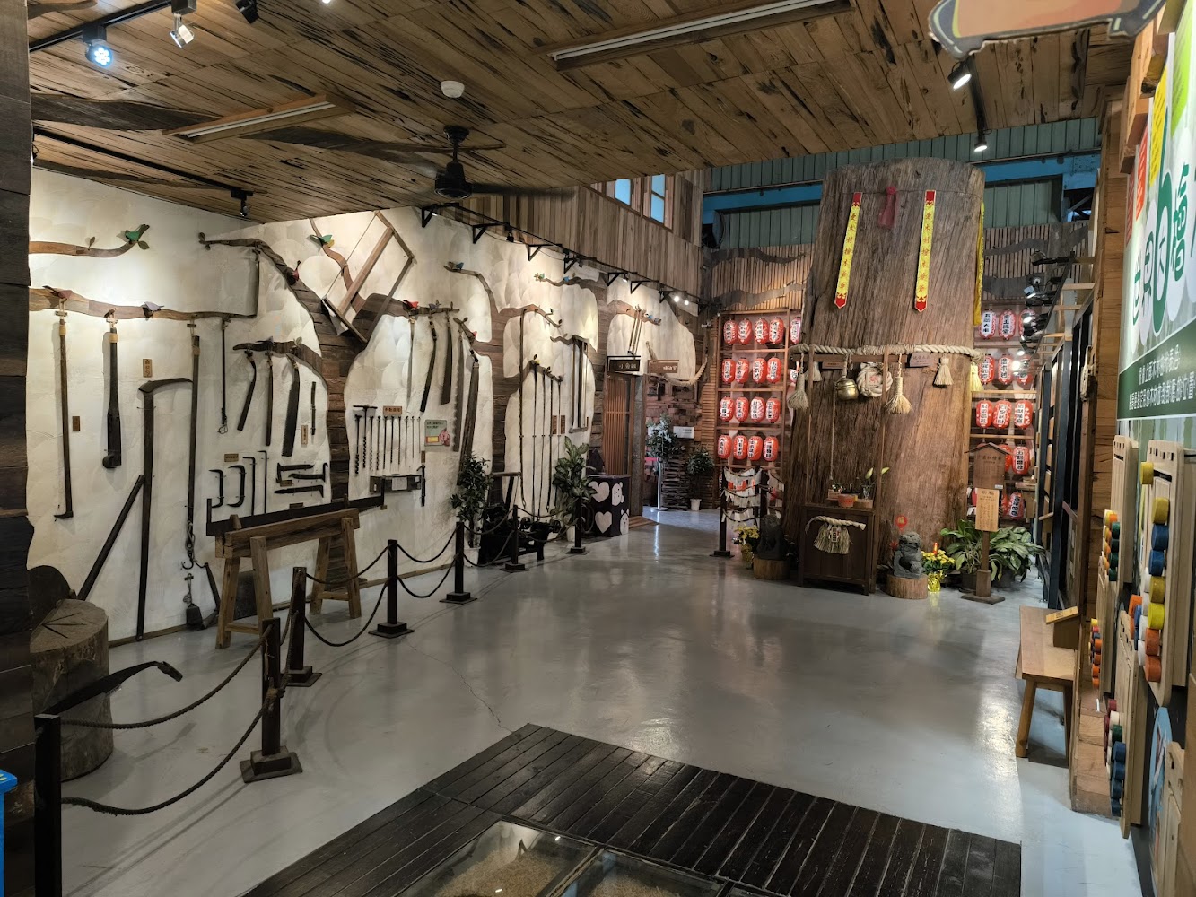 木工主題展覽空間，牆上陳列傳統木工工具與巨大樹幹造景