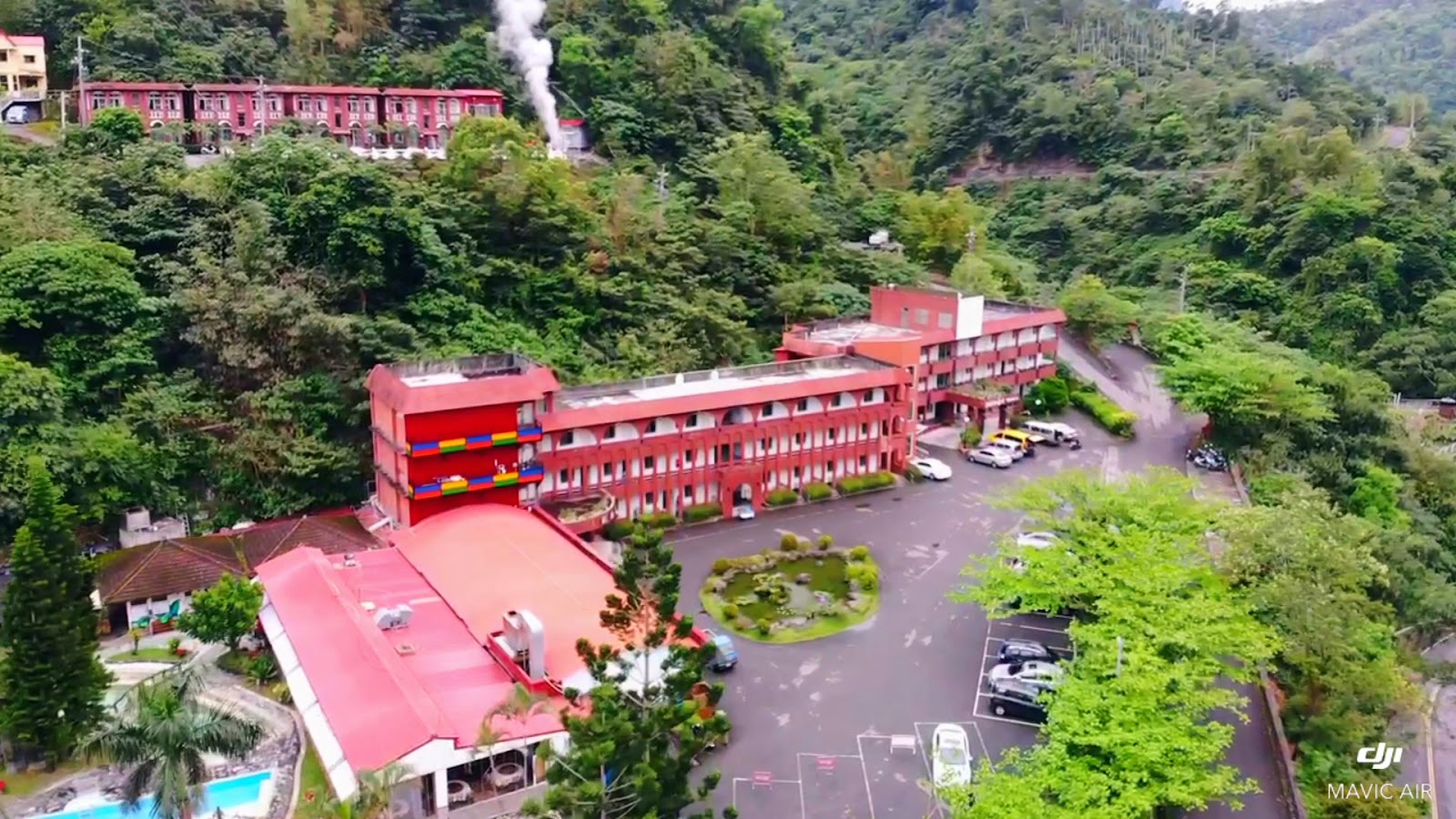 台東知本泓泉溫泉渡假村無人機空拍，紅色建築群散布山林間，溫泉蒸氣裊裊