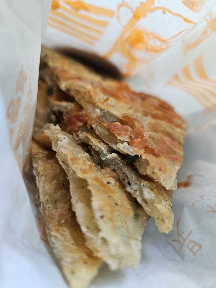 紙袋中的蔥油餅切片表面有醬料