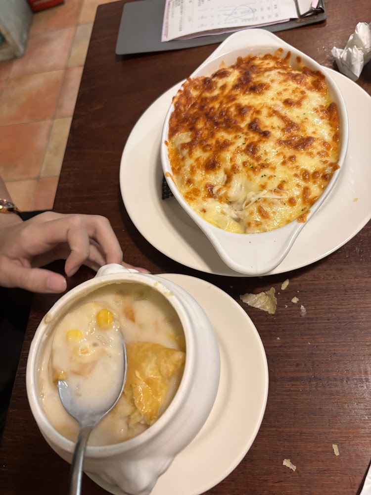 這張圖片主要有焗烤飯和一盅奶油濃湯。焗烤飯表面金黃酥脆，奶油濃湯內有玉米和酥皮，色澤誘人，看起來十分美味。