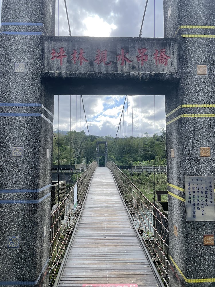 坪林親水吊橋木板橋面與石碑,背景是綠色山林