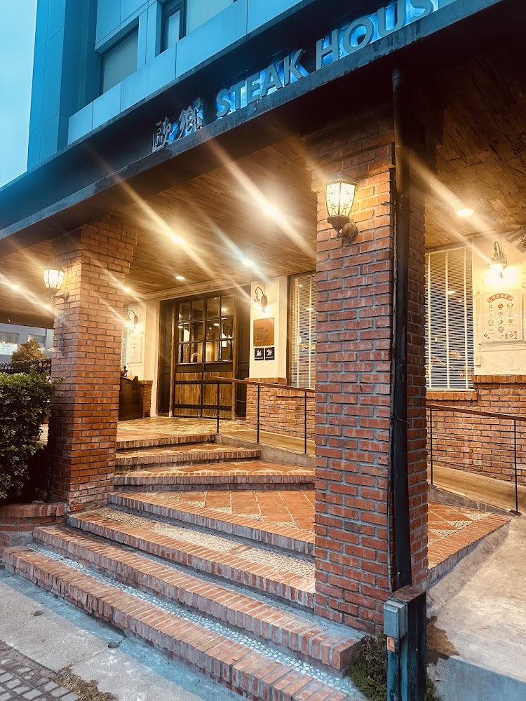 紅磚外牆與暖色燈光的牛排館入口